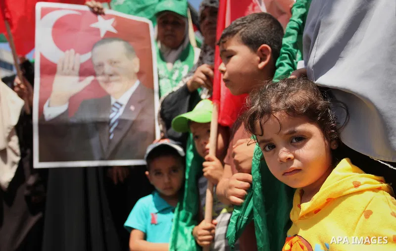 Palestinian supporters of the Hamas movement hold portraits of Turkish President Recep Tayyip Erdogan as they shout slogans against the military coup attempt in Turkey, during a demonstration in Gaza City, on July 17, 20...