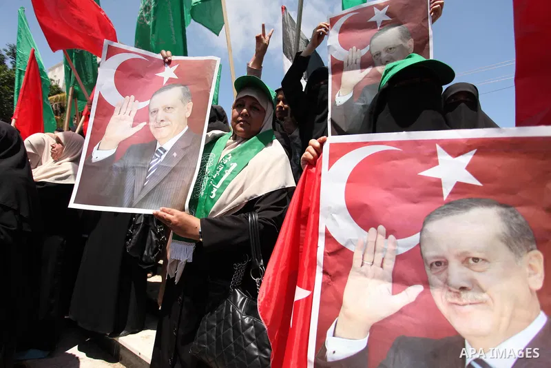 Palestinian supporters of the Hamas movement hold portraits of Turkish President Recep Tayyip Erdogan as they shout slogans against the military coup attempt in Turkey, during a demonstration in Gaza City, on July 17, 20...
