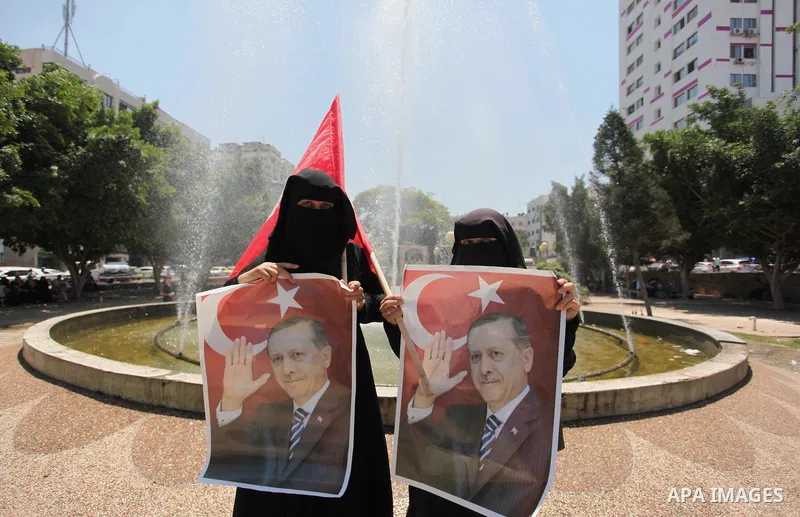 Palestinian supporters of the Hamas movement hold portraits of Turkish President Recep Tayyip Erdogan as they shout slogans against the military coup attempt in Turkey, during a demonstration in Gaza City, on July 17, 20...