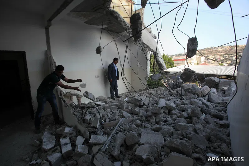 A Palestinian man checks on July 18, 2016 the rubble of a house belonging to a Palestinian man accused by Israeli authorities in taking part in an attack in Jerusalem in which an Israeli policewoman was killed, after it...