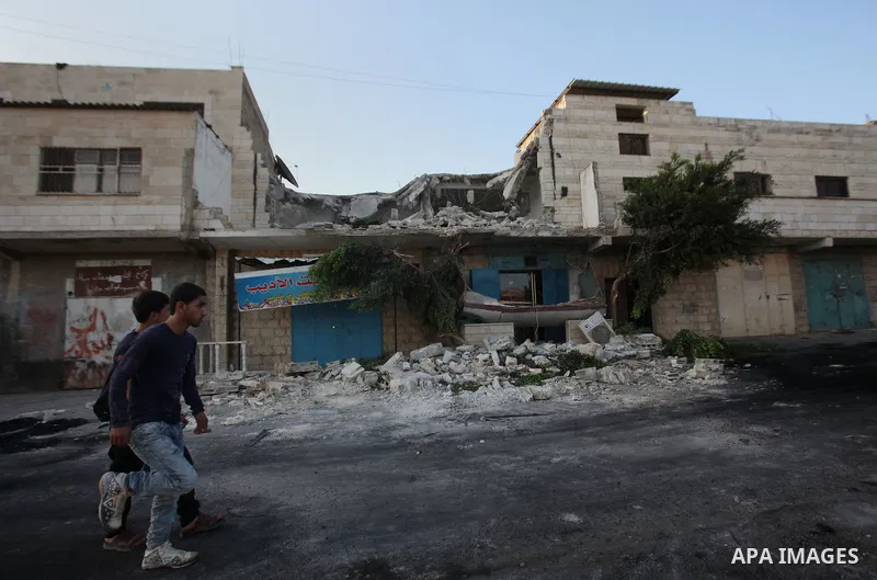 Palestinian men check on July 18, 2016 the rubble of a house belonging to a Palestinian man accused by Israeli authorities in taking part in an attack in Jerusalem in which an Israeli policewoman was killed, after it was...