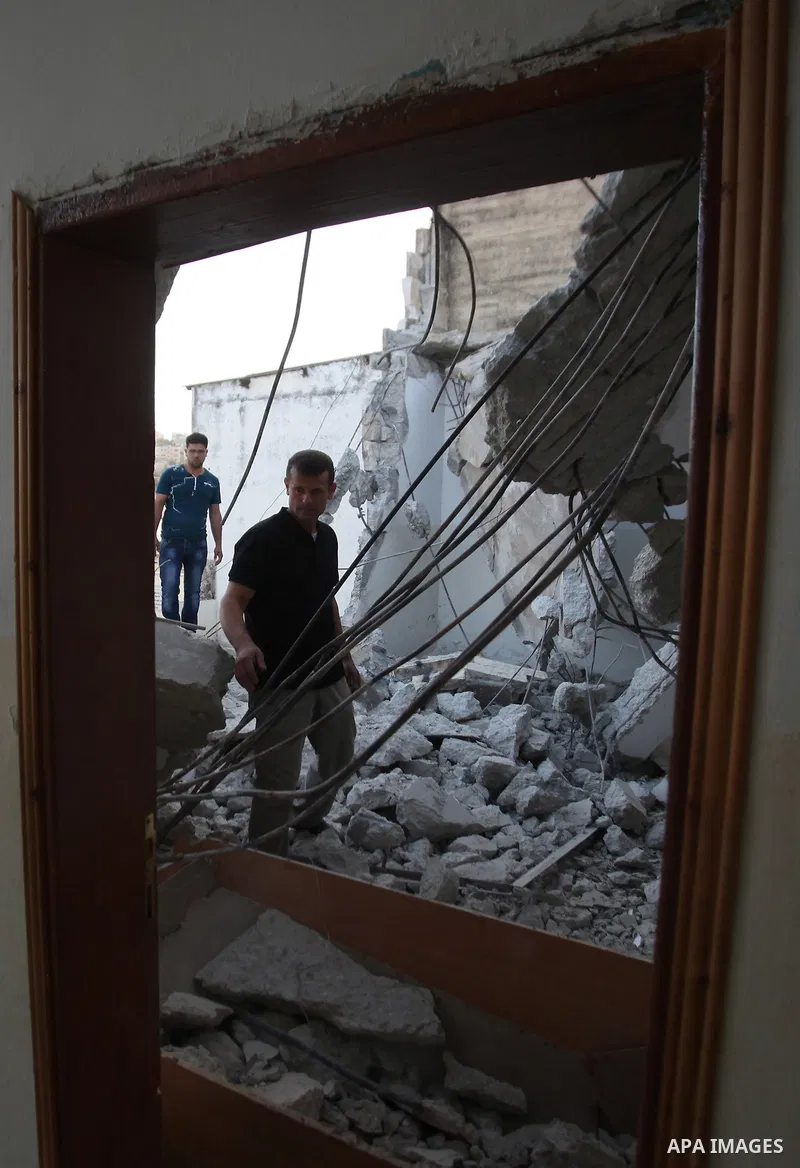 Palestinian men check on July 18, 2016 the rubble of a house belonging to a Palestinian man accused by Israeli authorities in taking part in an attack in Jerusalem in which an Israeli policewoman was killed, after it was...