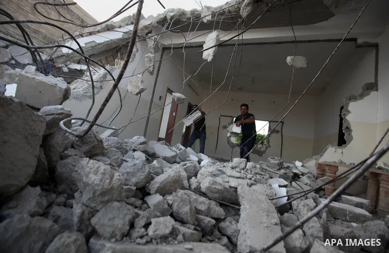 Palestinian men check on July 18, 2016 the rubble of a house belonging to a Palestinian man accused by Israeli authorities in taking part in an attack in Jerusalem in which an Israeli policewoman was killed, after it was...