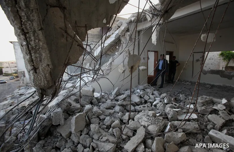 Palestinian men check on July 18, 2016 the rubble of a house belonging to a Palestinian man accused by Israeli authorities in taking part in an attack in Jerusalem in which an Israeli policewoman was killed, after it was...