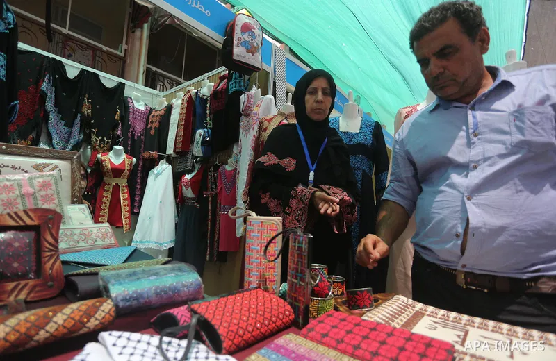 Palestinians attend the opening of an exhibition, in Gaza city, on July 18, 2016. Photo by Mohammed Asad