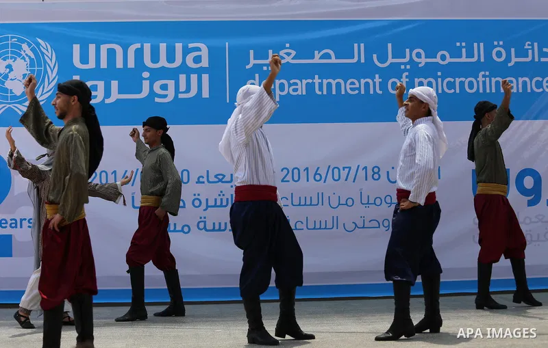 Palestinians youth participate in dancing of "Dabka" during the opening of an exhibition, in Gaza city, on July 18, 2016. Photo by Mohammed Asad