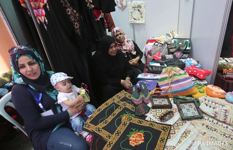 Palestinians attend the opening of an exhibition, in Gaza city, on July 18, 2016. Photo by Mohammed Asad