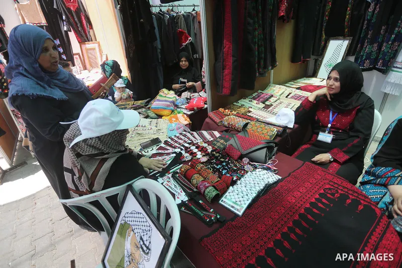 Palestinians attend the opening of an exhibition, in Gaza city, on July 18, 2016. Photo by Mohammed Asad