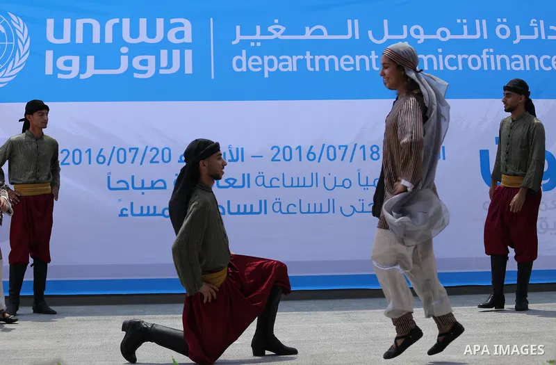 Palestinians youth participate in dancing of "Dabka" during the opening of an exhibition, in Gaza city, on July 18, 2016. Photo by Mohammed Asad