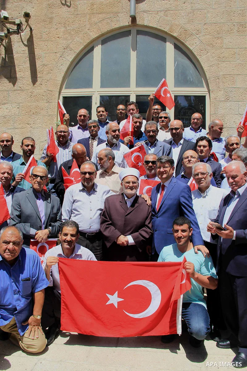 Palestinians wave Turkish flags during a protest against the military coup attempt in Turkey, in front of the Turkish consulate in east Jerusalem on July 18, 2016. Photo by Mahfouz Abu Turk