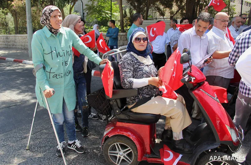 Palestinians wave Turkish flags during a protest against the military coup attempt in Turkey, in front of the Turkish consulate in east Jerusalem on July 18, 2016. Photo by Mahfouz Abu Turk