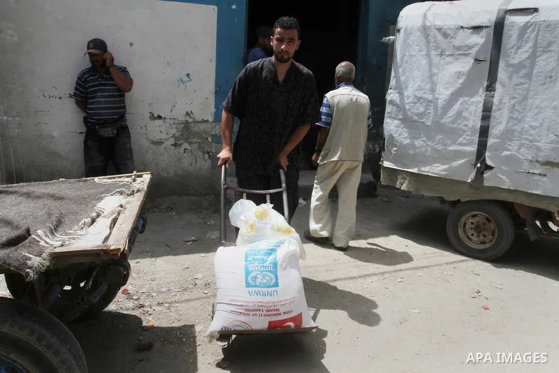 Palestinians receive Turkish aid at an aid distribution centre of the United Nations Relief and Works Agency (UNRWA) in the southern Gaza Strip town of Rafah, on July 18, 2016. Photo by Abed Rahim Khatib