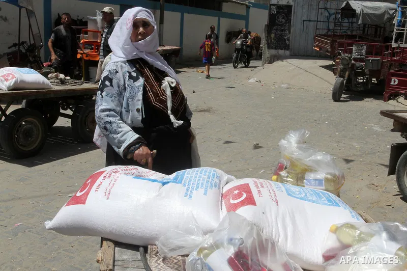 Palestinians receive Turkish aid at an aid distribution centre of the United Nations Relief and Works Agency (UNRWA) in the southern Gaza Strip town of Rafah, on July 18, 2016. Photo by Abed Rahim Khatib