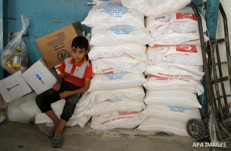 Palestinians receive Turkish aid at an aid distribution centre of the United Nations Relief and Works Agency (UNRWA) in the southern Gaza Strip town of Rafah, on July 18, 2016. Photo by Abed Rahim Khatib
