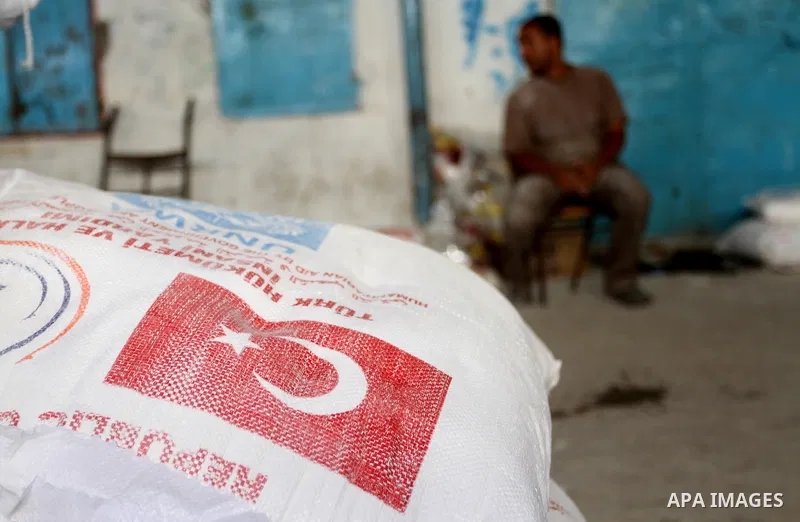 Palestinians receive Turkish aid at an aid distribution centre of the United Nations Relief and Works Agency (UNRWA) in the southern Gaza Strip town of Rafah, on July 18, 2016. Photo by Abed Rahim Khatib