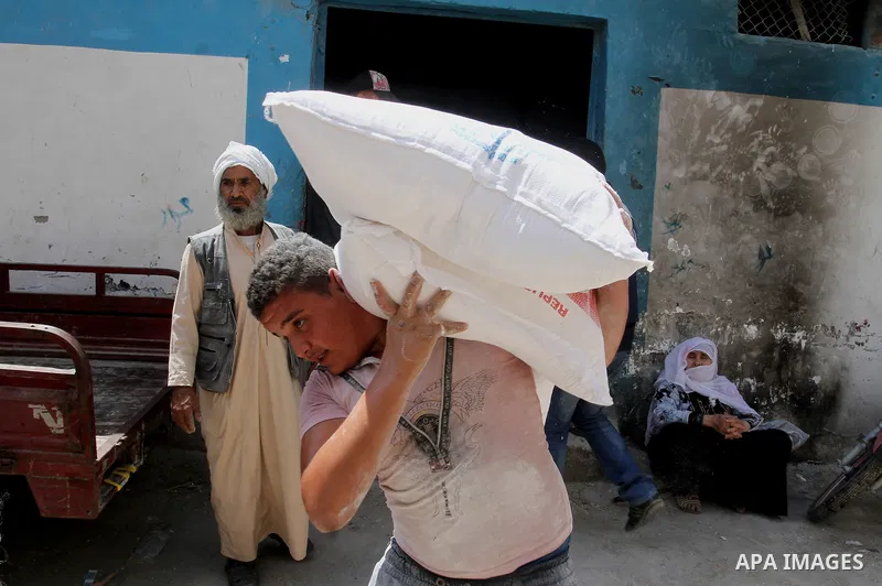 Palestinians receive Turkish aid at an aid distribution centre of the United Nations Relief and Works Agency (UNRWA) in the southern Gaza Strip town of Rafah, on July 18, 2016. Photo by Abed Rahim Khatib
