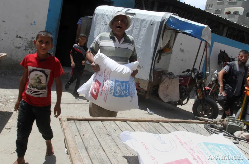 Palestinians receive Turkish aid at an aid distribution centre of the United Nations Relief and Works Agency (UNRWA) in the southern Gaza Strip town of Rafah, on July 18, 2016. Photo by Abed Rahim Khatib