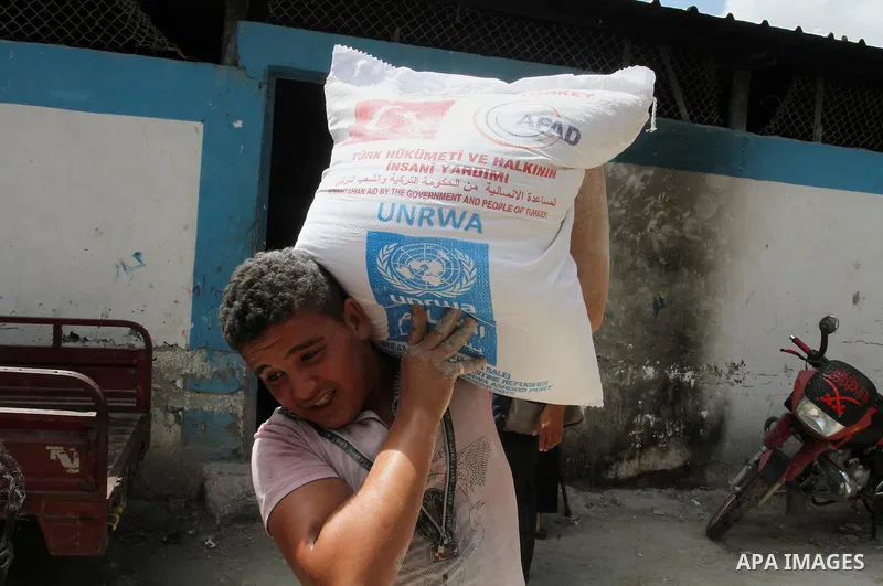 Palestinians receive Turkish aid at an aid distribution centre of the United Nations Relief and Works Agency (UNRWA) in the southern Gaza Strip town of Rafah, on July 18, 2016. Photo by Abed Rahim Khatib