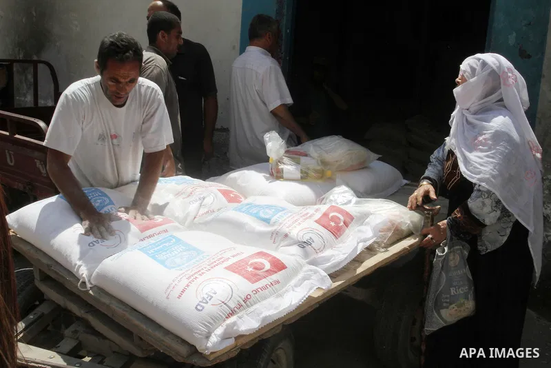 Palestinians receive Turkish aid at an aid distribution centre of the United Nations Relief and Works Agency (UNRWA) in the southern Gaza Strip town of Rafah, on July 18, 2016. Photo by Abed Rahim Khatib