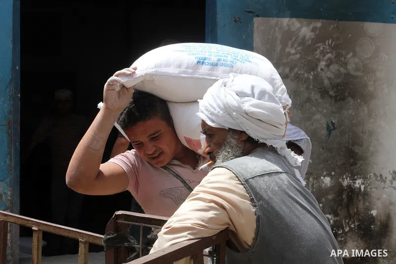 Palestinians receive Turkish aid at an aid distribution centre of the United Nations Relief and Works Agency (UNRWA) in the southern Gaza Strip town of Rafah, on July 18, 2016. Photo by Abed Rahim Khatib