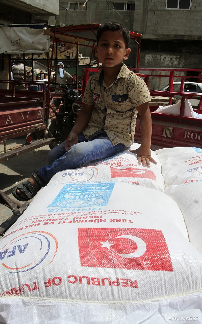 Palestinians receive Turkish aid at an aid distribution centre of the United Nations Relief and Works Agency (UNRWA) in the southern Gaza Strip town of Rafah, on July 18, 2016. Photo by Abed Rahim Khatib