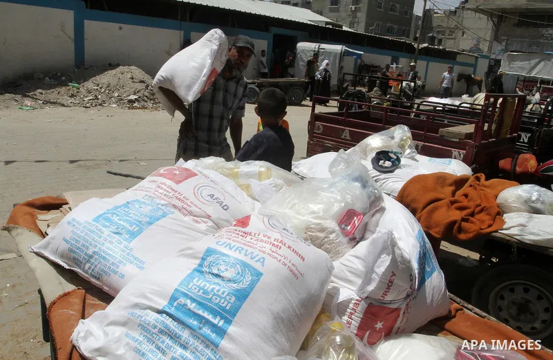 Palestinians receive Turkish aid at an aid distribution centre of the United Nations Relief and Works Agency (UNRWA) in the southern Gaza Strip town of Rafah, on July 18, 2016. Photo by Abed Rahim Khatib