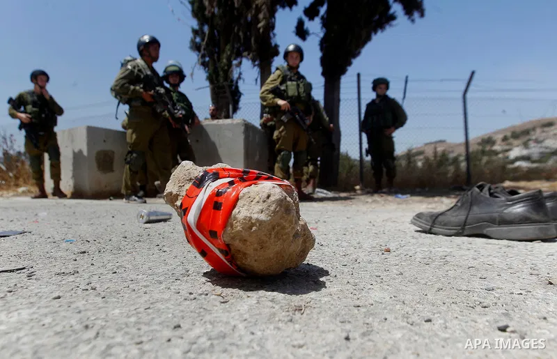The shoes of a Palestinian assailant are seen on the ground after she stabbed and wounded two Israeli soldiers before being hit by a gunshot next to the entrance of the al-Arub refugee camp near the city of Hebron in the...