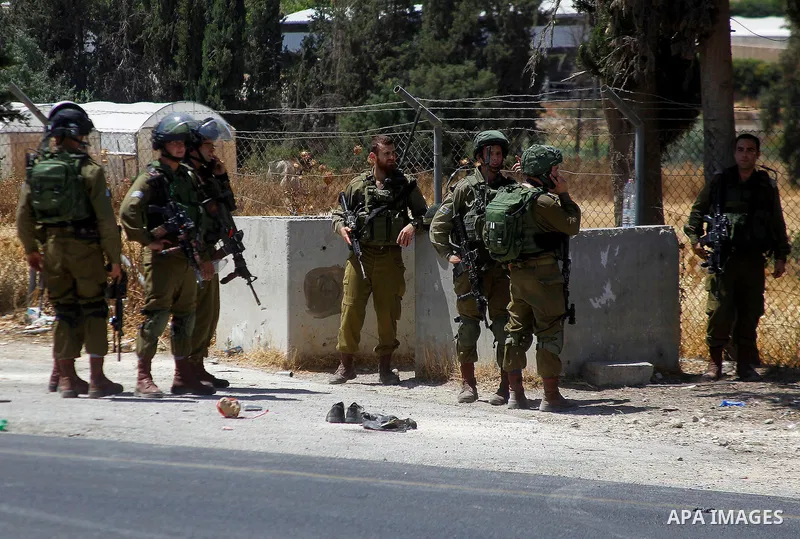 Israeli soldiers are seen at the site of a stabbing attack by a Palestinian man next to the entrance of the al-Arub refugee camp near the city of Hebron in the Israeli-occupied West Bank on July 18, 2016 in which two sol...