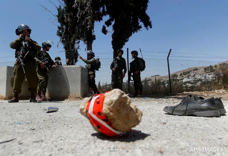 The shoes of a Palestinian assailant are seen on the ground after she stabbed and wounded two Israeli soldiers before being hit by a gunshot next to the entrance of the al-Arub refugee camp near the city of Hebron in the...
