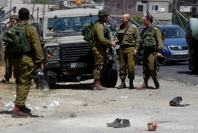 Israeli soldiers are seen at the site of a stabbing attack by a Palestinian man next to the entrance of the al-Arub refugee camp near the city of Hebron in the Israeli-occupied West Bank on July 18, 2016 in which two sol...
