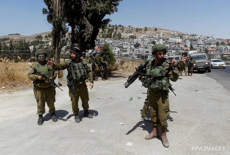 Israeli soldiers are seen at the site of a stabbing attack by a Palestinian man next to the entrance of the al-Arub refugee camp near the city of Hebron in the Israeli-occupied West Bank on July 18, 2016 in which two sol...
