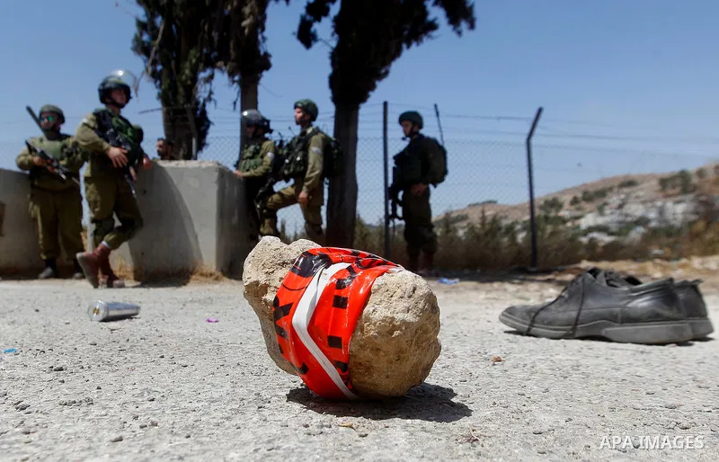 The shoes of a Palestinian assailant are seen on the ground after she stabbed and wounded two Israeli soldiers before being hit by a gunshot next to the entrance of the al-Arub refugee camp near the city of Hebron in the...