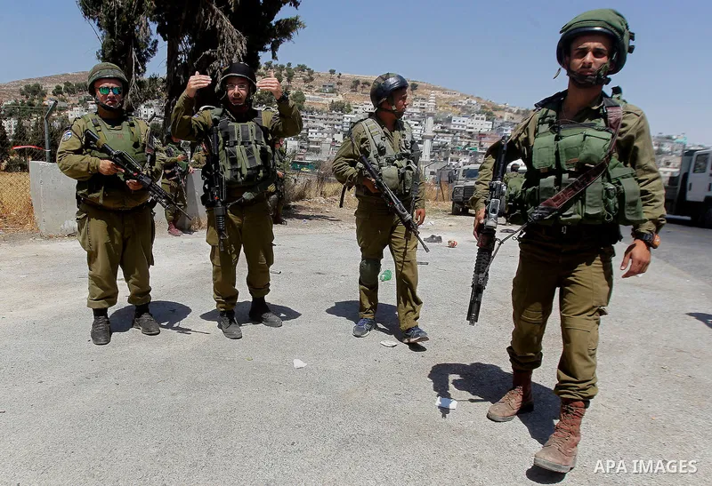 Israeli soldiers are seen at the site of a stabbing attack by a Palestinian man next to the entrance of the al-Arub refugee camp near the city of Hebron in the Israeli-occupied West Bank on July 18, 2016 in which two sol...