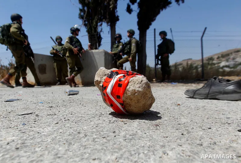 The shoes of a Palestinian assailant are seen on the ground after she stabbed and wounded two Israeli soldiers before being hit by a gunshot next to the entrance of the al-Arub refugee camp near the city of Hebron in the...