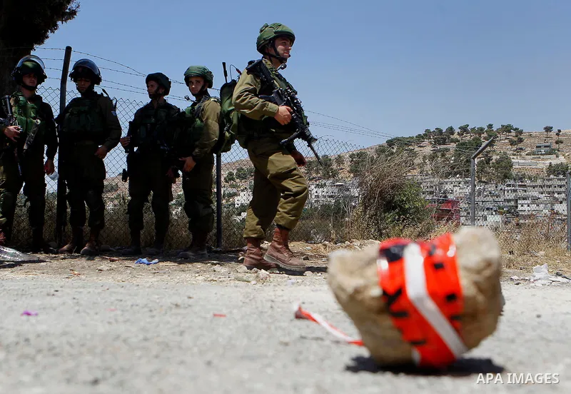The shoes of a Palestinian assailant are seen on the ground after she stabbed and wounded two Israeli soldiers before being hit by a gunshot next to the entrance of the al-Arub refugee camp near the city of Hebron in the...