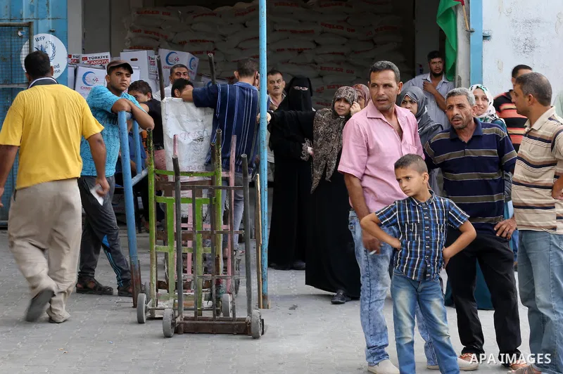 Palestinians receive Turkish aid at an aid distribution centre in Gaza city, on July 19, 2016. The aid, consisting of flour, sugar and rice, was allowed into the Palestinian territory via Israel’s Kerem Shalom crossing a...