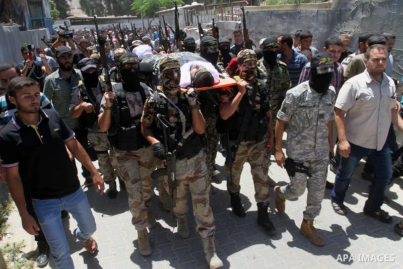 Palestinian members of the Islamic Jihad's armed wing, the Al-Quds Brigades, carry the body of a fellow militant, Salah al-Astal, who died after a tunnel collapse in the Gaza Strip, during his funeral in Khan Younis in t...