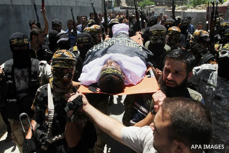 Palestinian members of the Islamic Jihad's armed wing, the Al-Quds Brigades, carry the body of a fellow militant, Salah al-Astal, who died after a tunnel collapse in the Gaza Strip, during his funeral in Khan Younis in t...