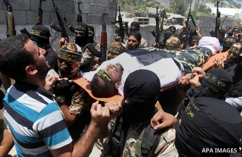 Palestinian members of the Islamic Jihad's armed wing, the Al-Quds Brigades, carry the body of a fellow militant, Salah al-Astal, who died after a tunnel collapse in the Gaza Strip, during his funeral in Khan Younis in t...