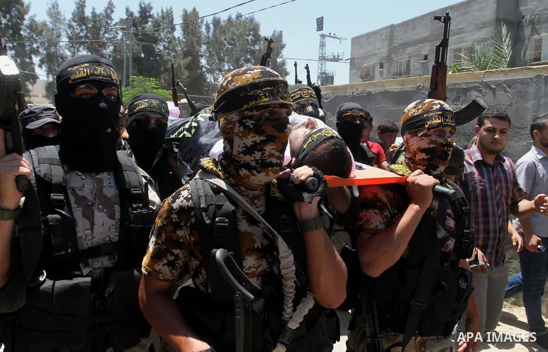 Palestinian members of the Islamic Jihad's armed wing, the Al-Quds Brigades, carry the body of a fellow militant, Salah al-Astal, who died after a tunnel collapse in the Gaza Strip, during his funeral in Khan Younis in t...