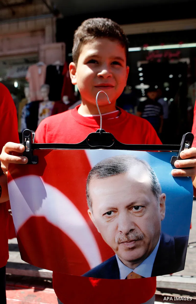 Palestinians hold portraits of Turkish President Recep Tayyip Erdogan during a protest against the military coup attempt in Turkey in the West bank city of Hebron 20 July 2016. Photo by Wisam Hashlamoun