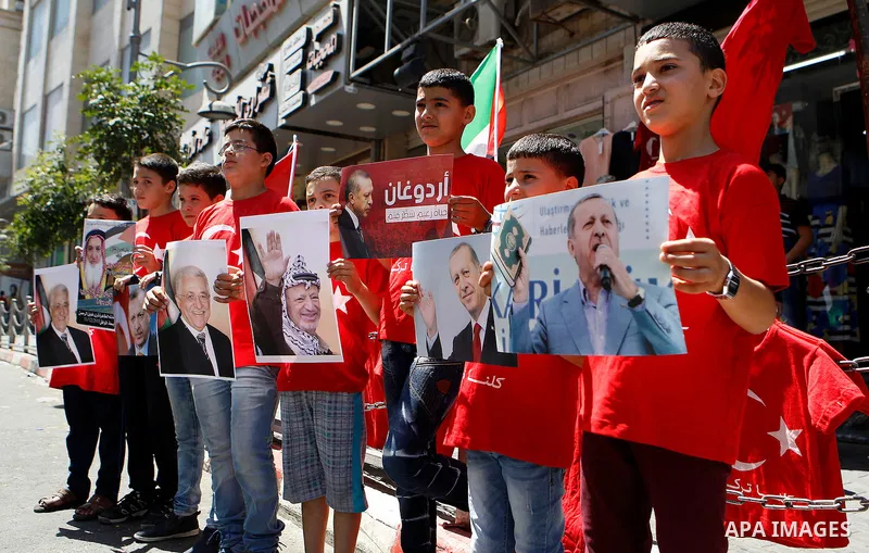 Palestinians hold portraits of Turkish President Recep Tayyip Erdogan during a protest against the military coup attempt in Turkey in the West bank city of Hebron 20 July 2016. Photo by Wisam Hashlamoun