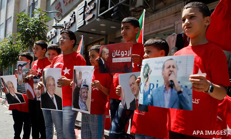 Palestinians hold portraits of Turkish President Recep Tayyip Erdogan during a protest against the military coup attempt in Turkey in the West bank city of Hebron 20 July 2016. Photo by Wisam Hashlamoun