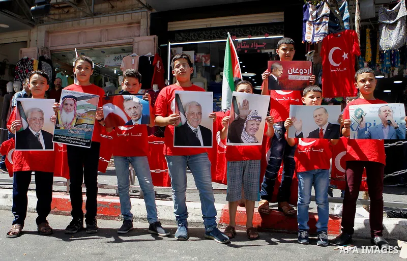 Palestinians hold portraits of Turkish President Recep Tayyip Erdogan during a protest against the military coup attempt in Turkey in the West bank city of Hebron 20 July 2016. Photo by Wisam Hashlamoun