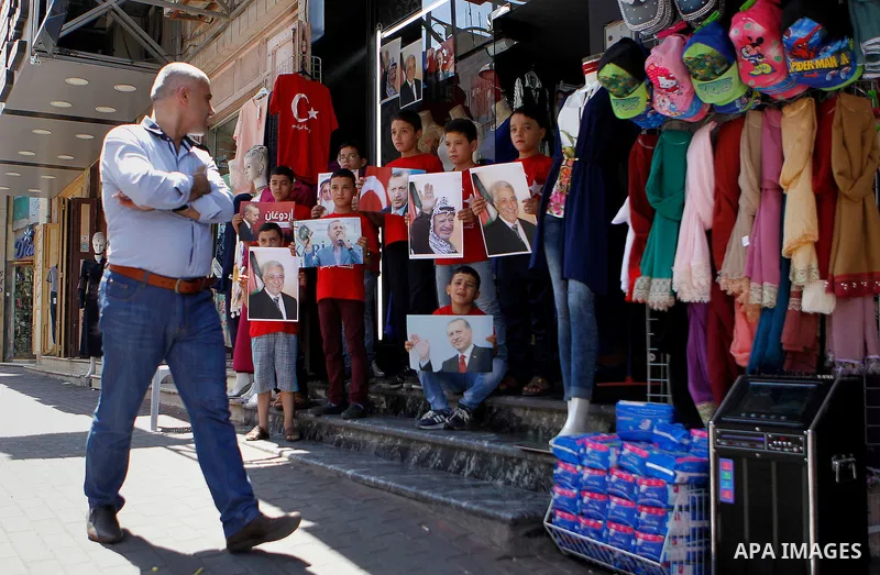Palestinians hold portraits of Turkish President Recep Tayyip Erdogan during a protest against the military coup attempt in Turkey in the West bank city of Hebron 20 July 2016. Photo by Wisam Hashlamoun