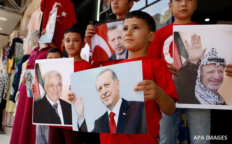 Palestinians hold portraits of Turkish President Recep Tayyip Erdogan during a protest against the military coup attempt in Turkey in the West bank city of Hebron 20 July 2016. Photo by Wisam Hashlamoun