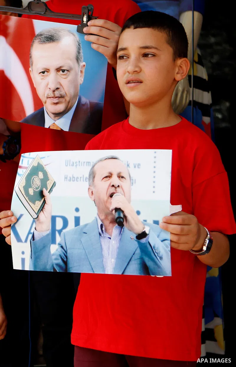 Palestinians hold portraits of Turkish President Recep Tayyip Erdogan during a protest against the military coup attempt in Turkey in the West bank city of Hebron 20 July 2016. Photo by Wisam Hashlamoun