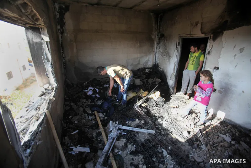 Palestinians inspect a damaged house following a blaze overnight in the village of Duma in the Israeli-occupied West Bank on July 20, 2016. The house is located in the Palestinian village where an arson attack by Jewish...