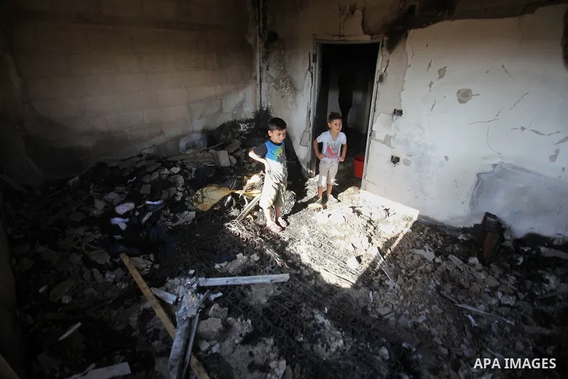 Palestinians inspect a damaged house following a blaze overnight in the village of Duma in the Israeli-occupied West Bank on July 20, 2016. The house is located in the Palestinian village where an arson attack by Jewish...