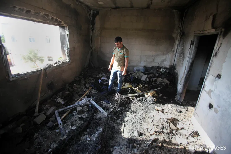Palestinians inspect a damaged house following a blaze overnight in the village of Duma in the Israeli-occupied West Bank on July 20, 2016. The house is located in the Palestinian village where an arson attack by Jewish...